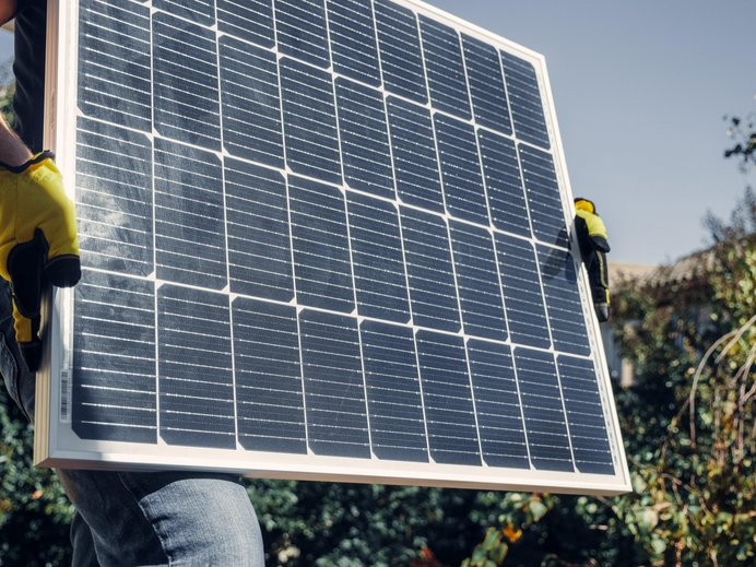 Eine Person hält ein Solar-Modul in der Hand